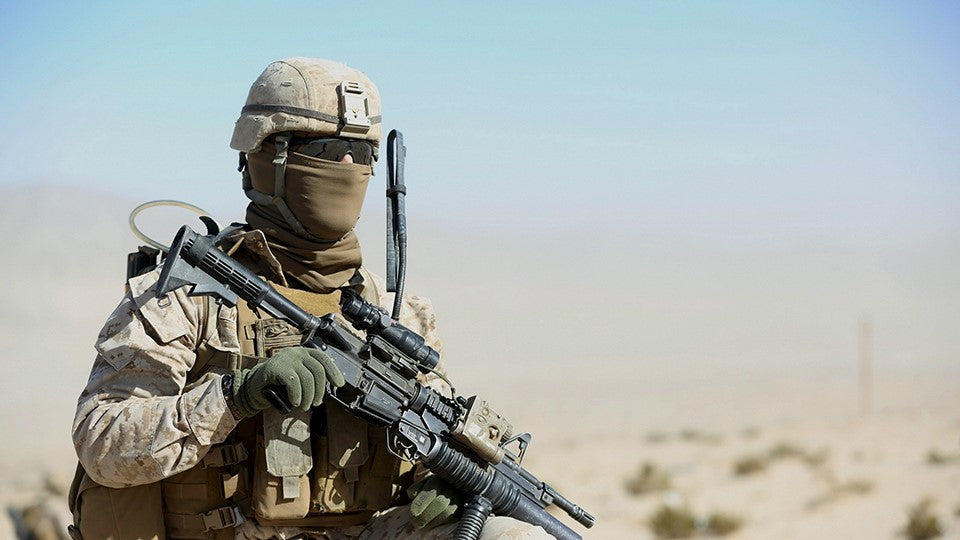 Picture of military person holding tactical gear.